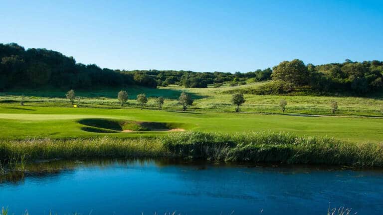 nau-hotels-and-resorts-a-morgado-golf-course-with-a-pond-in-the-foreground